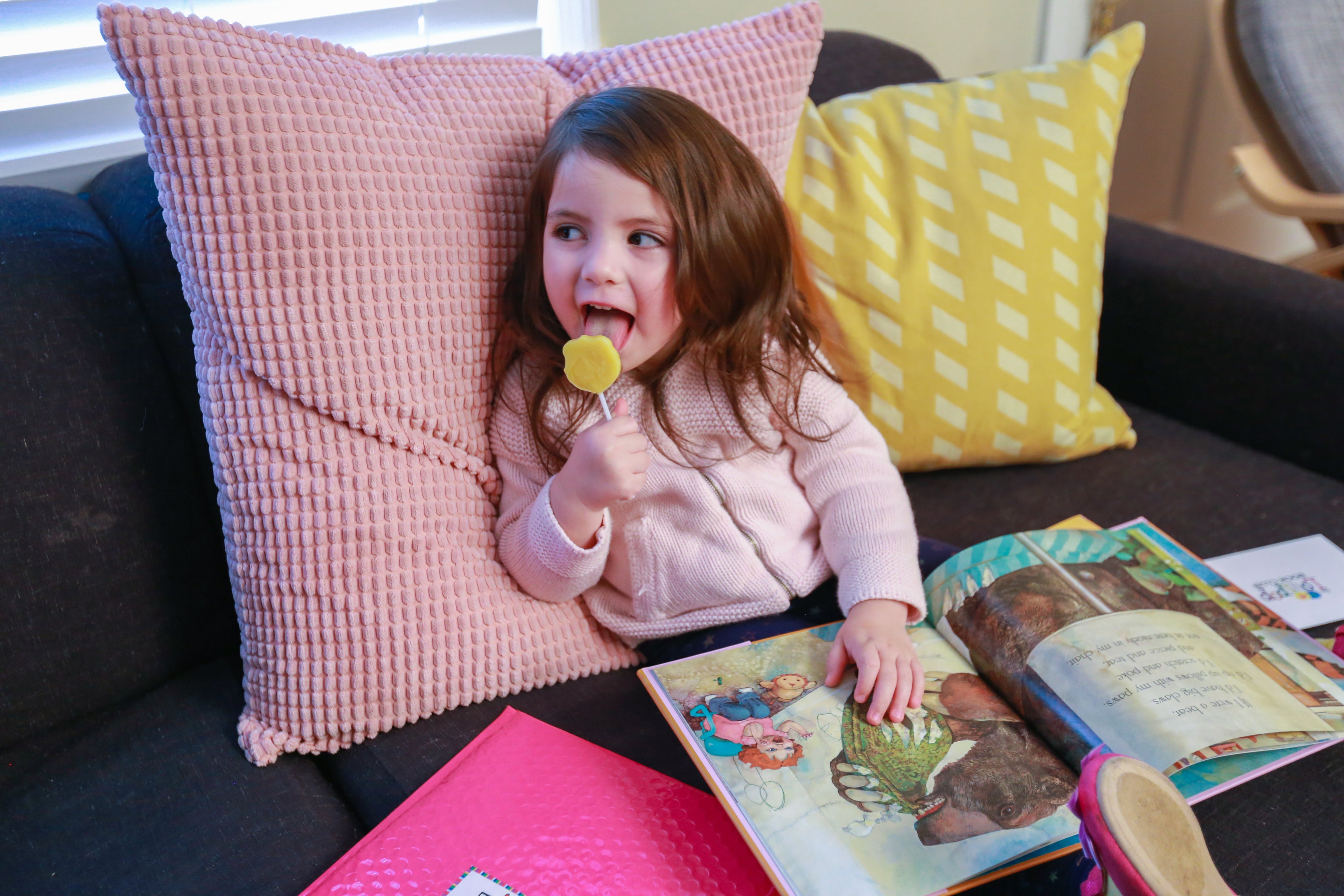 girl licking lollipop and reading books
