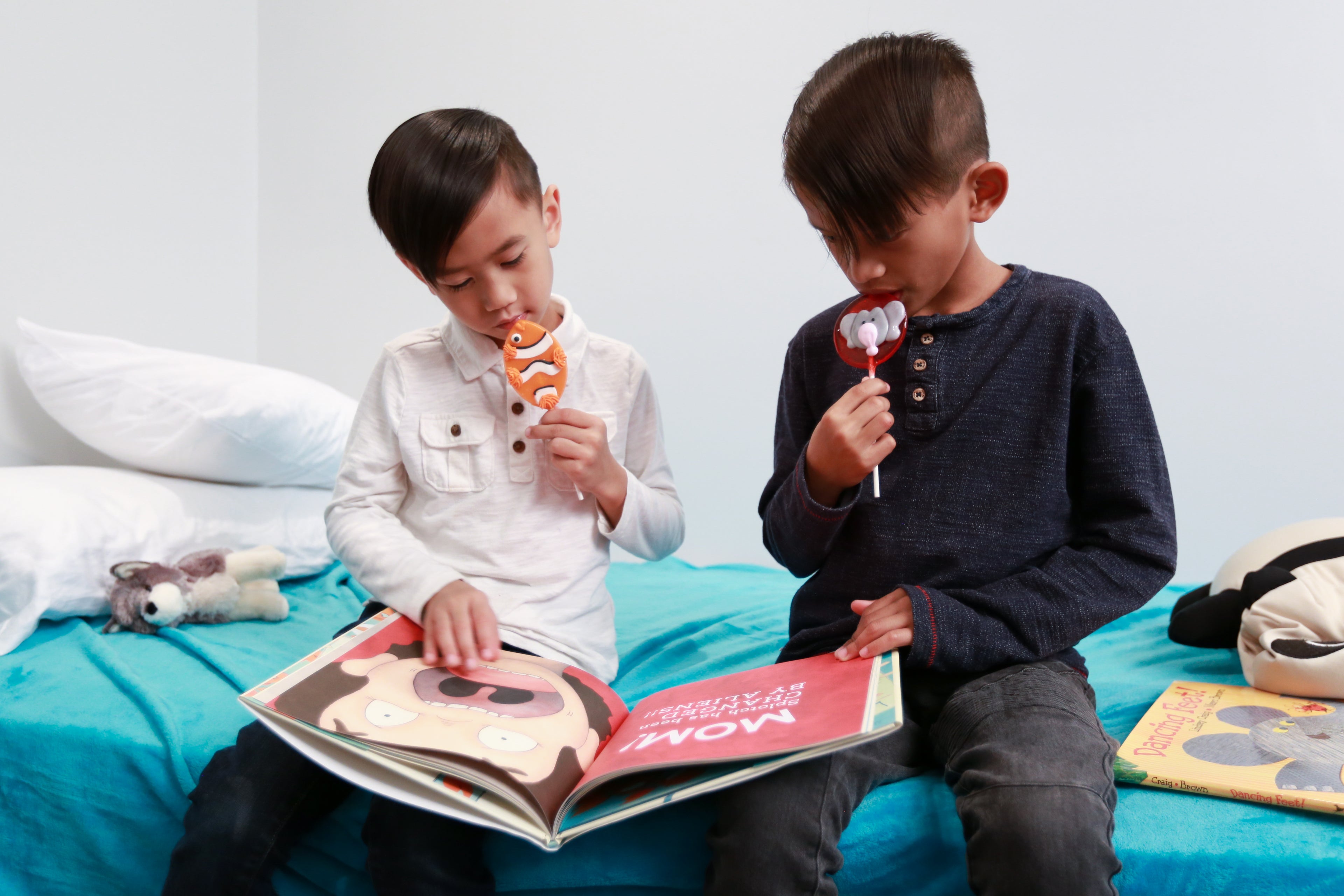 boys reading books and licking lollipops